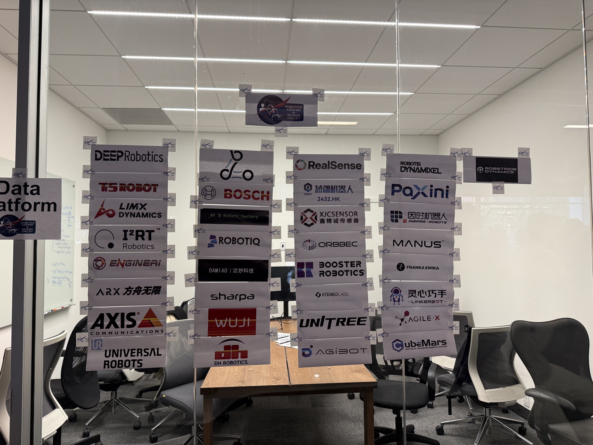 Sponsor wall with 30+ robotics companies including Unitree, Bosch, RealSense, Paxini, AgiBot, MANUS at SVRC May 2026